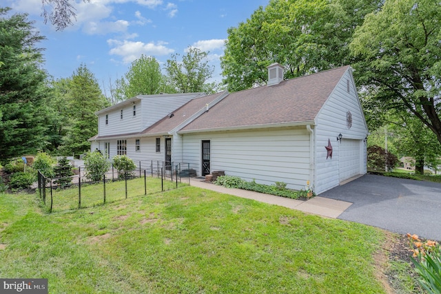 4210 Mcintosh Rd, Harrisburg, PA 17112 - back of house with asphalt driveway, a chimney, a shingled roof, and a detached garage