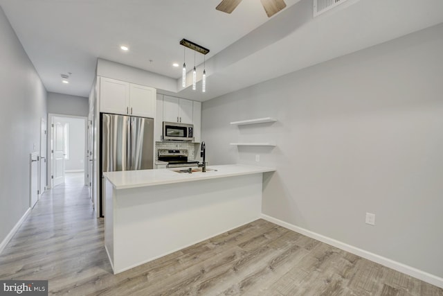 832 19th St NE Unit C, Washington, DC 20002 - kitchen with appliances with stainless steel finishes, open shelves, baseboards, a peninsula, and recessed lighting