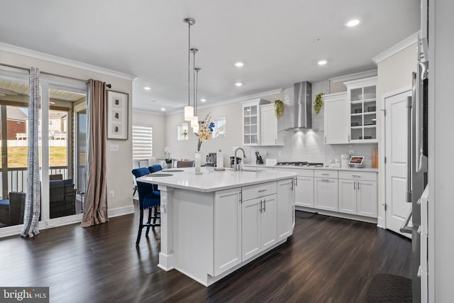 4387 Shakespeare Cir, White Plains, MD 20695 - kitchen featuring wall chimney range hood, ornamental molding, dark wood-style flooring, a center island with sink, and tasteful backsplash