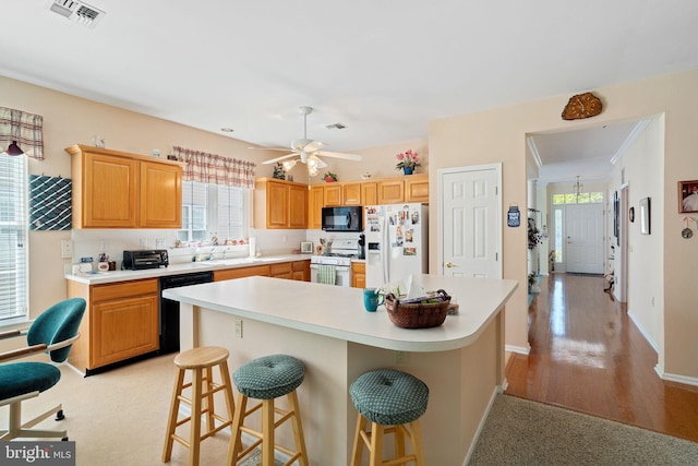 4 Forest Lake Ct, Barnegat, NJ 08005 - kitchen with black appliances, healthy amount of natural light, light countertops, and a kitchen bar