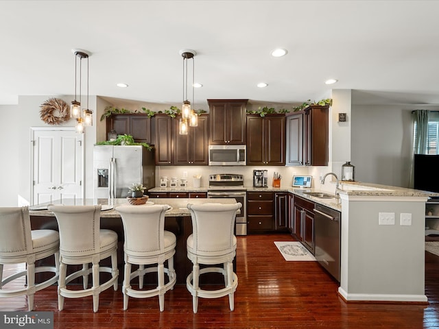 110 Fritillary Ct, Lake Frederick, VA 22630 - kitchen featuring appliances with stainless steel finishes, a sink, dark brown cabinets, light stone counters, and dark wood-type flooring