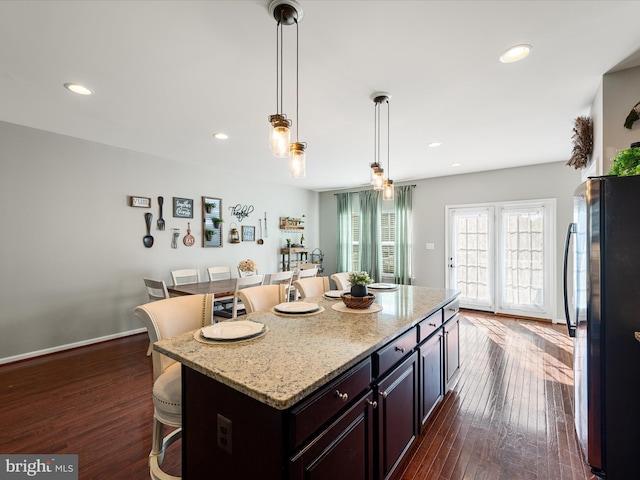 110 Fritillary Ct, Lake Frederick, VA 22630 - kitchen with freestanding refrigerator, a kitchen breakfast bar, dark wood-style floors, recessed lighting, and light stone counters