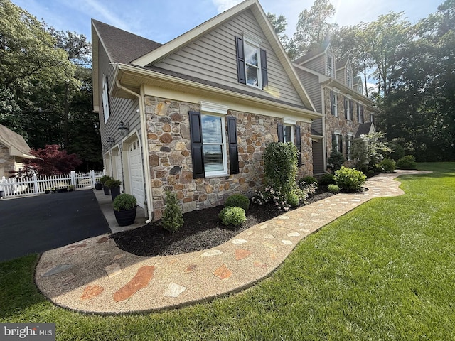 12534 Fawn Dr, Laurel, DE 19956 - view of side of home featuring stone siding, asphalt driveway, and an attached garage