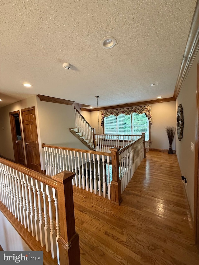 12534 Fawn Dr, Laurel, DE 19956 - hall with an upstairs landing, wood finished floors, a textured ceiling, ornamental molding, and recessed lighting