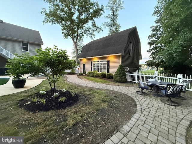 12534 Fawn Dr, Laurel, DE 19956 - rear view of house with a gambrel roof, a patio area, a shingled roof, and an outbuilding
