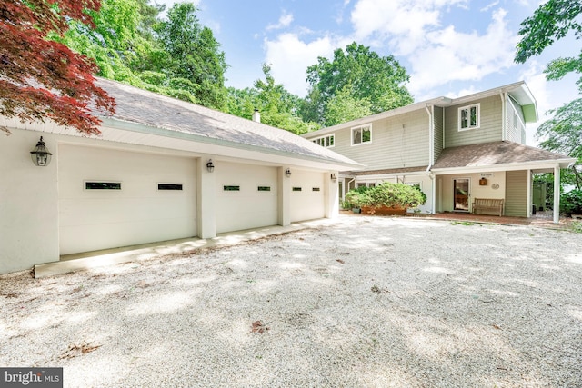 view of property exterior featuring a garage, a shingled roof, and driveway
