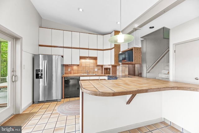 kitchen featuring black appliances, white cabinets, light tile patterned floors, tile countertops, and a kitchen breakfast bar