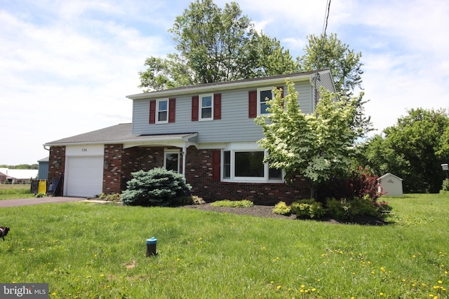 view of front of home with brick siding, an attached garage, asphalt driveway, and a front lawn