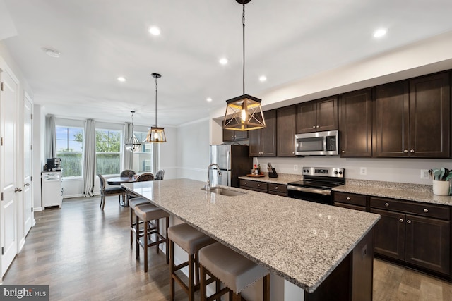 18216 Summit Pointe Dr, Triangle, VA 22172 - kitchen featuring stainless steel appliances, a sink, dark brown cabinets, a breakfast bar area, and recessed lighting