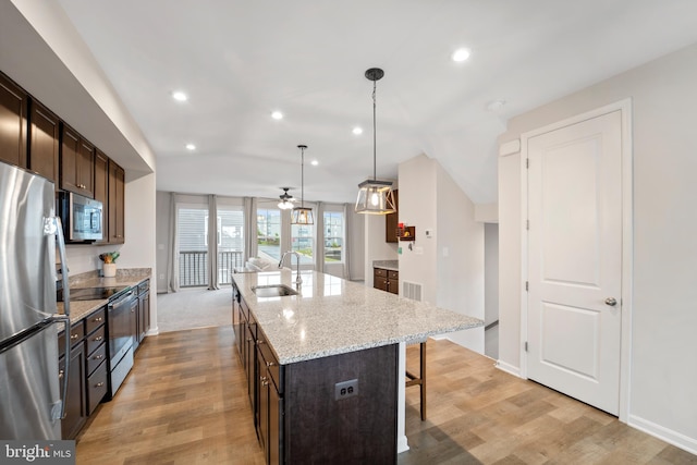 18216 Summit Pointe Dr, Triangle, VA 22172 - kitchen with appliances with stainless steel finishes, a sink, light wood-style floors, a breakfast bar area, and recessed lighting