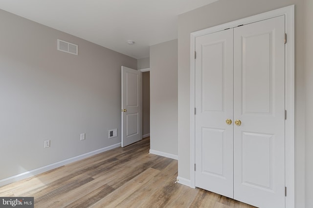 921 N Rose St, Baltimore, MD 21205 - unfurnished bedroom featuring baseboards, a closet, and light wood finished floors