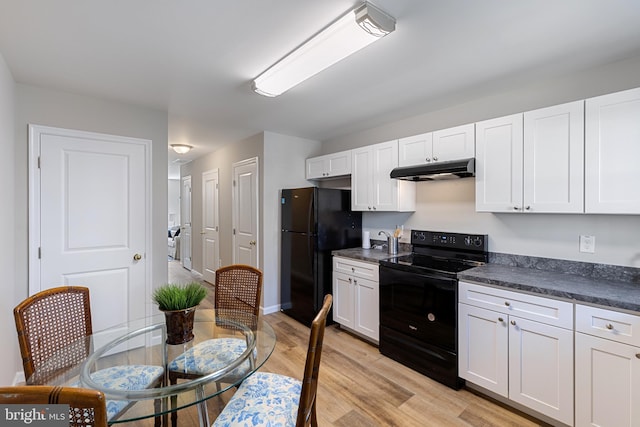 921 N Rose St, Baltimore, MD 21205 - kitchen featuring black appliances, under cabinet range hood, dark countertops, light wood-style flooring, and white cabinets