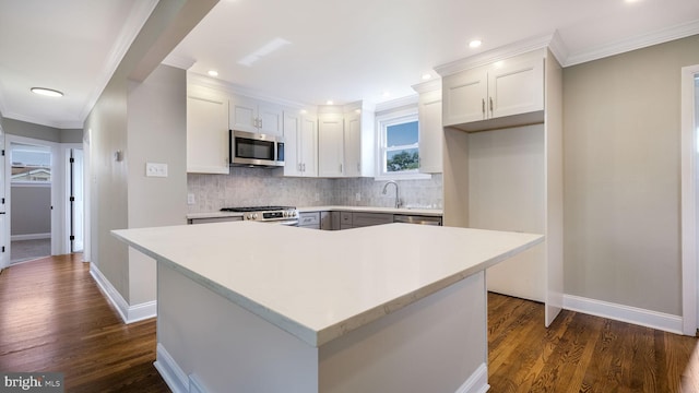 949 Marshall Dr, Warminster, PA 18974 - kitchen featuring stainless steel appliances, tasteful backsplash, dark wood-style flooring, ornamental molding, and light countertops
