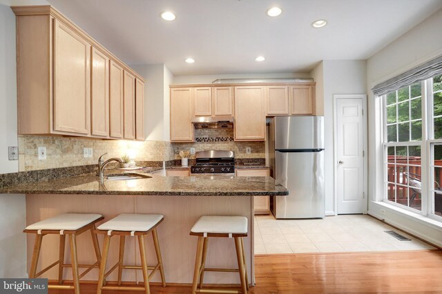 13943 Lullaby Rd, Germantown, MD 20874 - kitchen featuring freestanding refrigerator, range with gas stovetop, a sink, a peninsula, and light brown cabinets