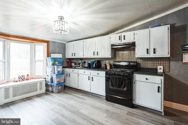 kitchen featuring black range with gas cooktop, under cabinet range hood, radiator heating unit, dark countertops, and white cabinetry