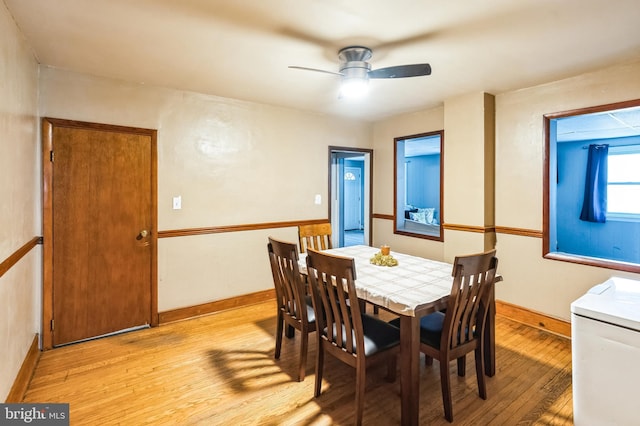 dining room featuring light wood-type flooring, a ceiling fan, and baseboards