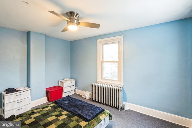bedroom featuring radiator, dark carpet, ceiling fan, and baseboards
