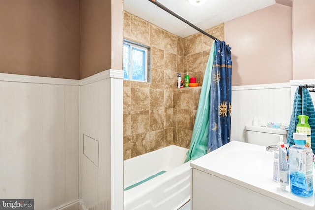 full bath with a wainscoted wall and shower / tub combo