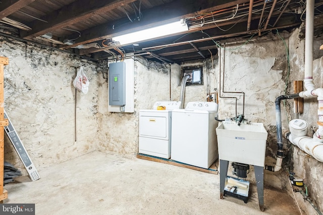 below grade area with electric panel, washing machine and dryer, and a sink