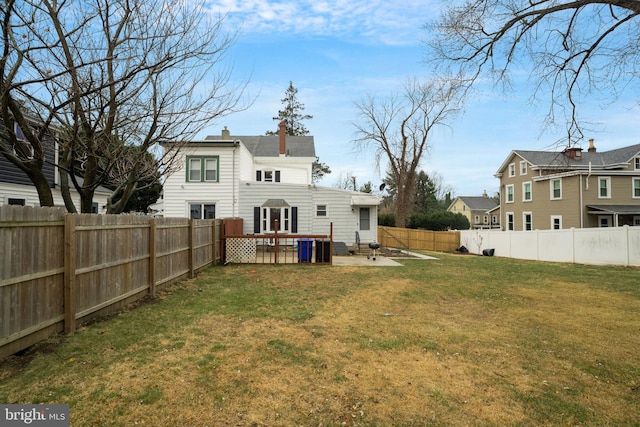 back of property with a chimney and a deck