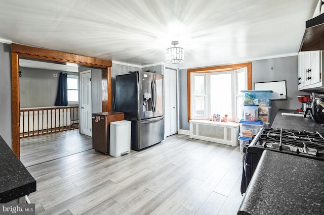 kitchen with stainless steel fridge with ice dispenser, a chandelier, light wood-type flooring, dark countertops, and ornamental molding