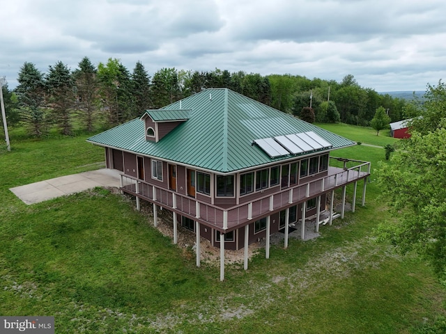 9207 Douglas Rd, Olanta, PA 16863 - rear view of house featuring a standing seam roof, a lawn, driveway, metal roof, and an attached garage