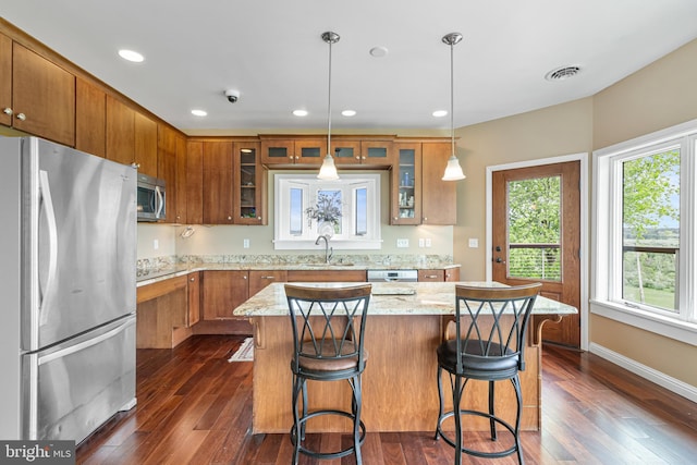 9207 Douglas Rd, Olanta, PA 16863 - kitchen with appliances with stainless steel finishes, a sink, brown cabinetry, dark wood-style flooring, and light stone countertops