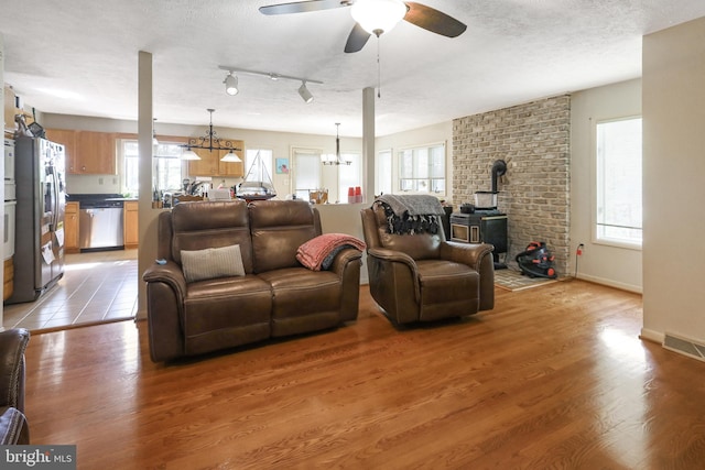200 Sunset Cir, Cross Junction, VA 22625 - living room with a wood stove, ceiling fan, light wood-type flooring, healthy amount of natural light, and a textured ceiling