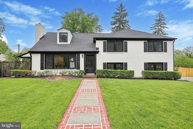 tri-level home featuring roof with shingles, a chimney, and brick siding