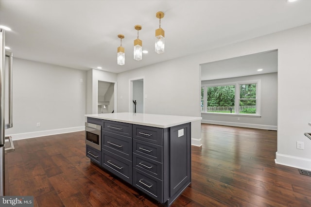 kitchen with light countertops, dark wood-type flooring, baseboards, decorative light fixtures, and recessed lighting