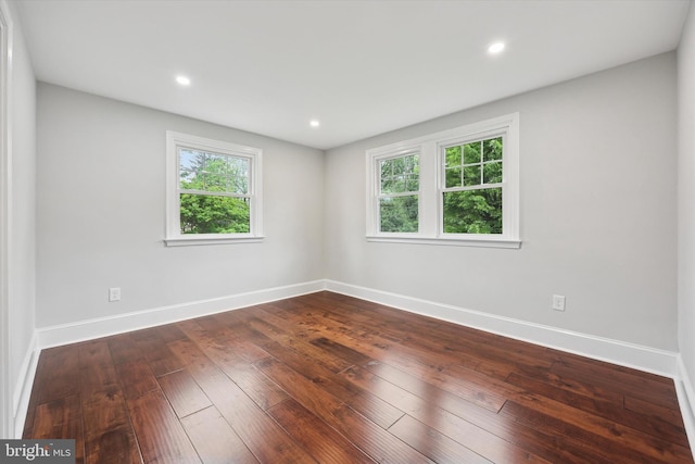 unfurnished room featuring baseboards, dark wood finished floors, and recessed lighting