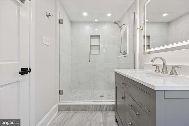 full bathroom featuring a stall shower, marble finish floors, vanity, baseboards, and recessed lighting