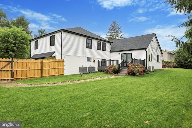 rear view of property featuring a wooden deck, cooling unit, and a shingled roof