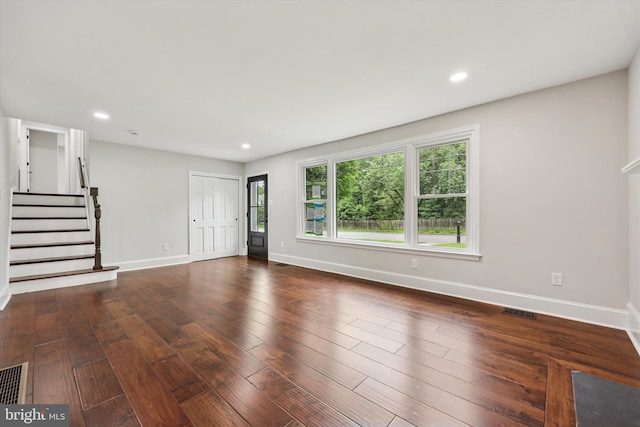 unfurnished living room featuring baseboards, stairs, wood-type flooring, and recessed lighting