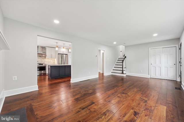 unfurnished living room with stairway, dark wood-style floors, recessed lighting, and baseboards