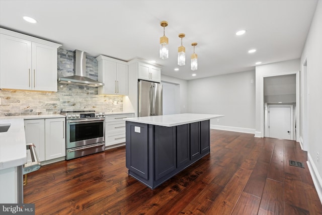kitchen featuring stainless steel appliances, wall chimney exhaust hood, backsplash, light countertops, and recessed lighting