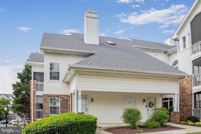 6510 Lake Park Dr Unit 2E/201, Greenbelt, MD 20770 - view of front facade with a chimney, a shingled roof, and brick siding