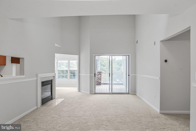 6510 Lake Park Dr Unit 2E/201, Greenbelt, MD 20770 - unfurnished living room featuring a towering ceiling, carpet flooring, baseboards, and a premium fireplace