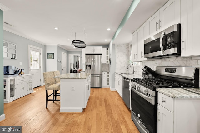 4521 Clay St NE, Washington, DC 20019 - kitchen with stainless steel appliances, a sink, a kitchen island, ornamental molding, and backsplash