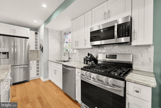 4521 Clay St NE, Washington, DC 20019 - kitchen featuring stainless steel appliances, a sink, white cabinets, backsplash, and recessed lighting