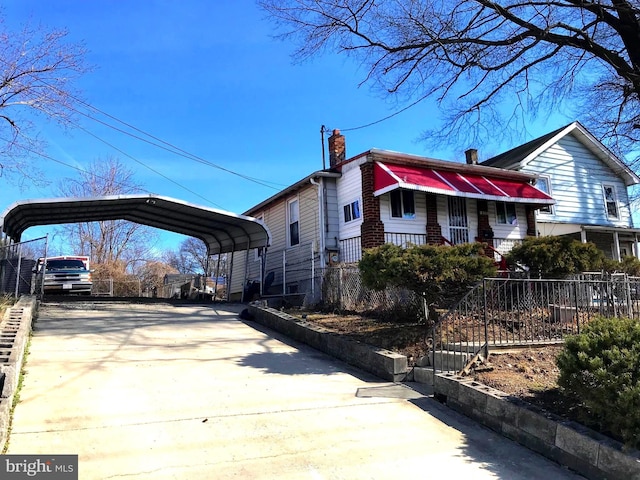 833 Eastern Ave, Fairmount Heights, MD 20743 - view of home's exterior featuring a carport, driveway, and a chimney
