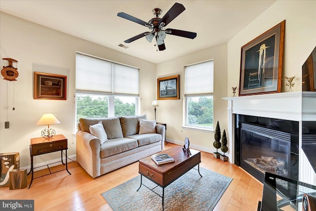 1050 Crest Way Unit 403, York, PA 17403 - living room featuring light wood-style flooring, ceiling fan, a glass covered fireplace, and baseboards