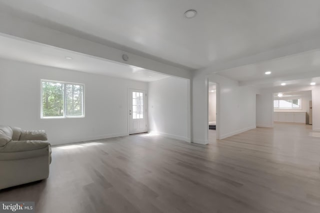 unfurnished living room with light wood finished floors, healthy amount of natural light, baseboards, and recessed lighting