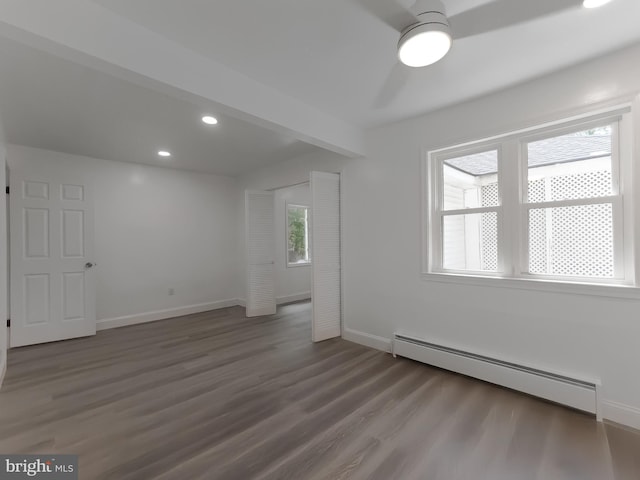 unfurnished room featuring a baseboard heating unit, wood finished floors, baseboards, and recessed lighting