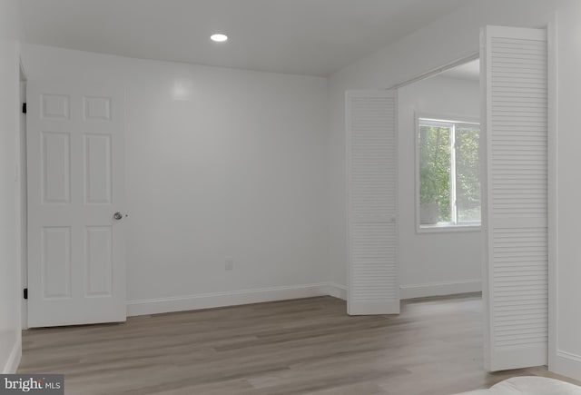 empty room with recessed lighting, light wood finished floors, and baseboards