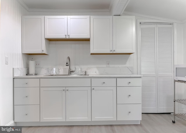 kitchen featuring a sink, light countertops, and white cabinets