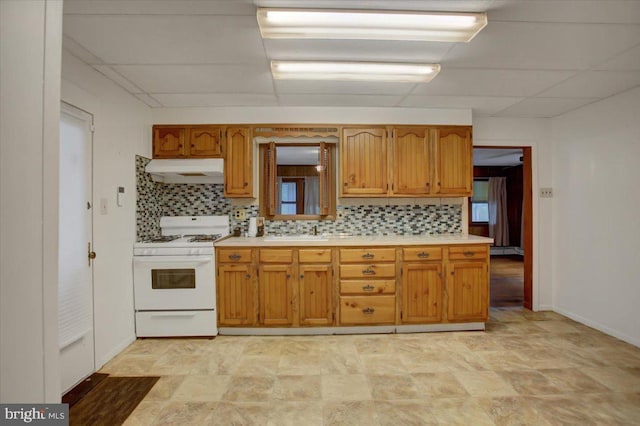 38 Mountain Rd, Orrtanna, PA 17353 - kitchen with white range with gas stovetop, under cabinet range hood, light countertops, and decorative backsplash