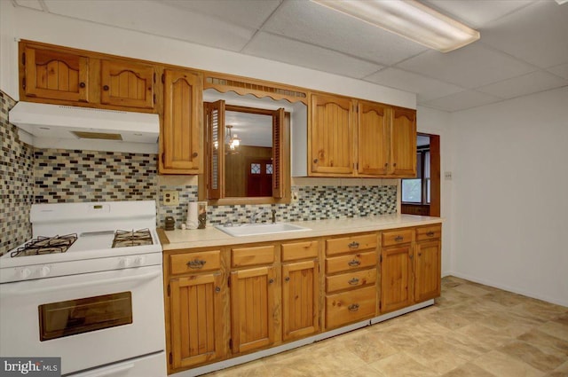 38 Mountain Rd, Orrtanna, PA 17353 - kitchen with white gas range oven, under cabinet range hood, a sink, a drop ceiling, and decorative backsplash