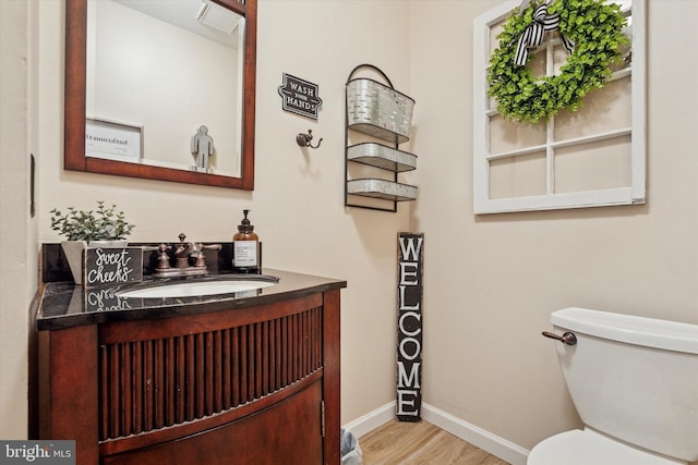 435 N Mount Vernon Cir, Bensalem, PA 19020 - half bathroom with baseboards, vanity, wood finished floors, and toilet