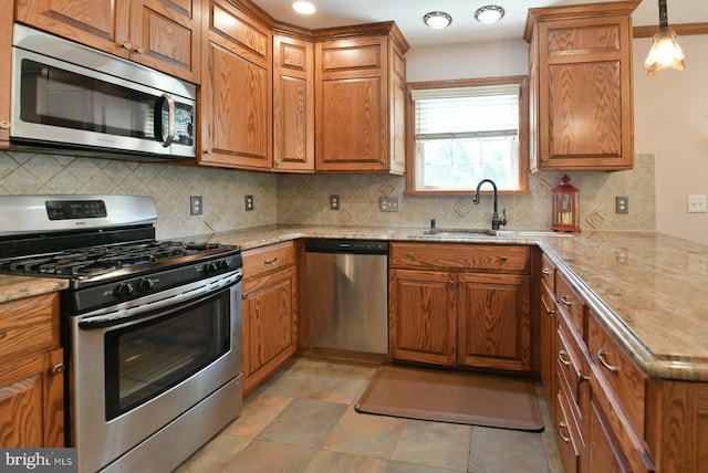 12 Ethan Ter, Woolwich Twp, NJ 08085 - kitchen with appliances with stainless steel finishes, a sink, brown cabinetry, backsplash, and a peninsula